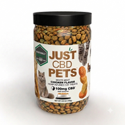 A jar of Just CBD Pets white meat chicken flavor hemp infused cat treats, featuring a black lid and a white label with images of a cat and kibble pieces, set against a plain white background.